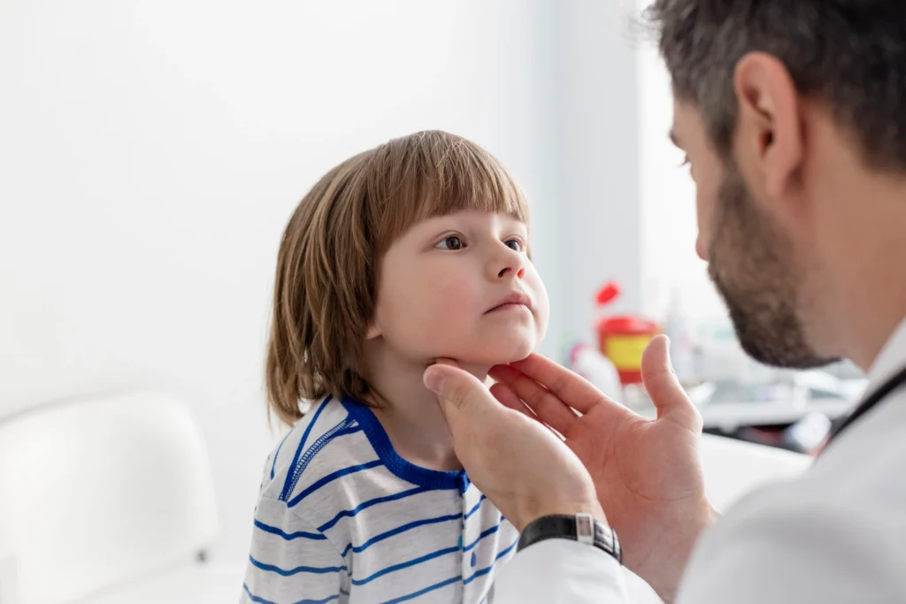 pediatrician checking on tonsil problem of a kid